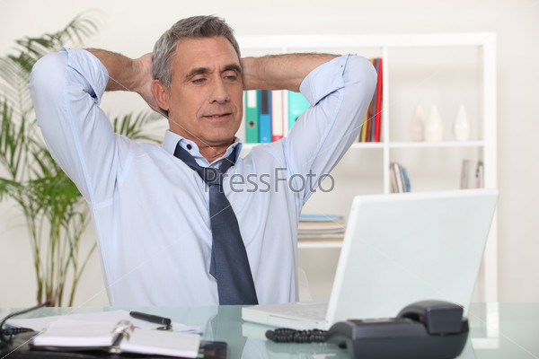 Businessman stretching at his desk