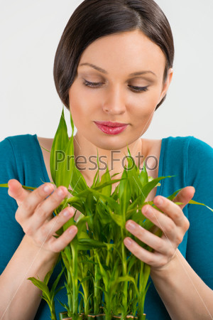 Woman holding lucky bamboo plant and taking care of it