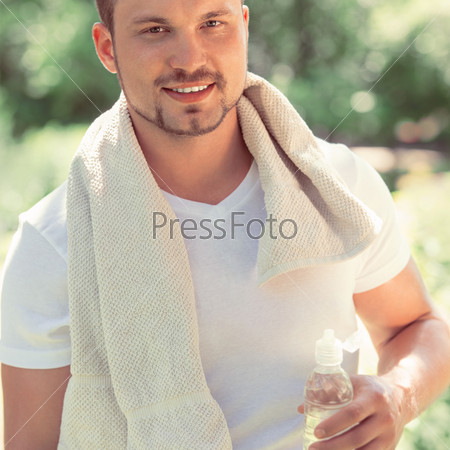 Man exhausted after the workout - relaxing and drinking water. Retro style photo