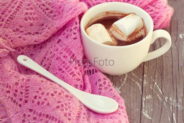 A rich cup of hot chocolate wrapped in a cozy winter scarf, stock photo