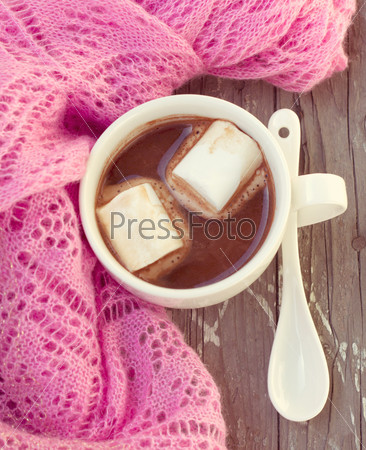 A rich cup of hot chocolate wrapped in a cozy winter scarf