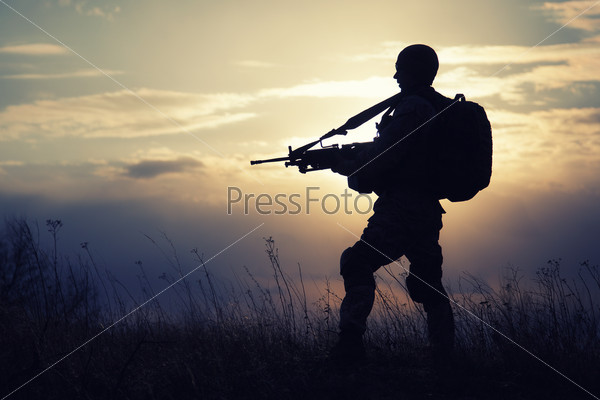 Silhouette of US marine with rifle  against the sunset