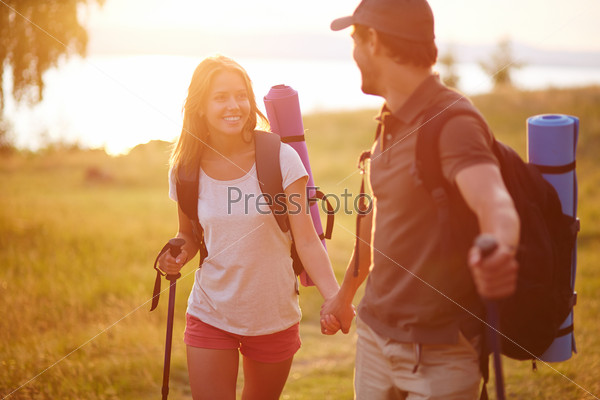 Portrait of couple of happy hikers walking in the countryside