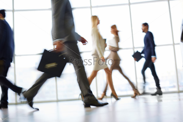 White collar workers going down office corridor during working day, stock photo