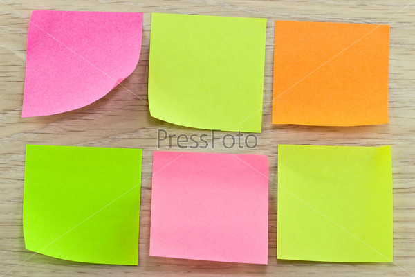 Six colorful sticky notes on wooden background