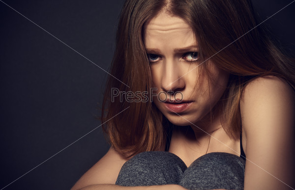 sad woman in depression and despair crying on black dark background