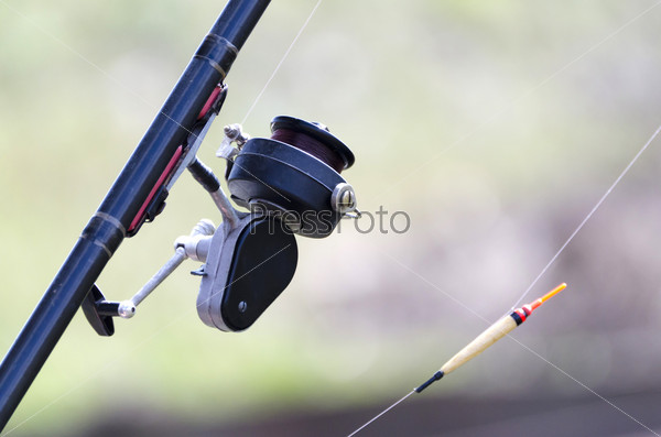 The fishing rod with reel and float closeup