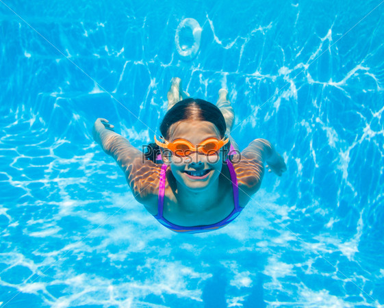 The cute girl swimming underwater and smiling