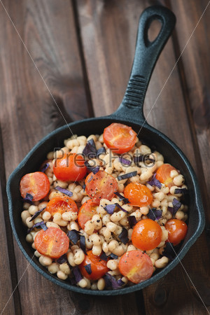 Roasted tomatoes with white beans in a frying pan, above view