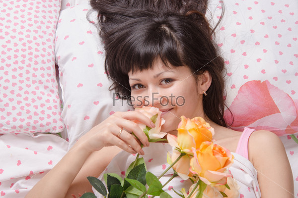 A beautiful young girl who lies in bed, gave flowers