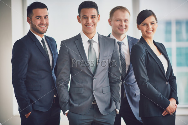 Portrait of confident business partners looking at camera with male leader in front