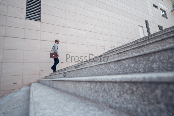 Stylish man going up the stairs, view from the side