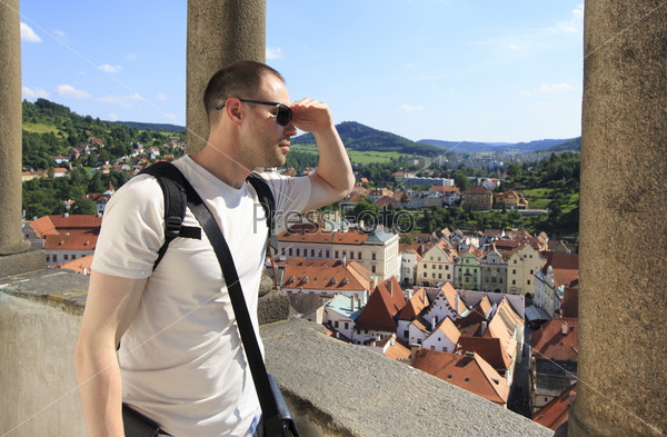 Tourist considers the historical city center from the tower. Cesky Krumlov in the Czech Republic.