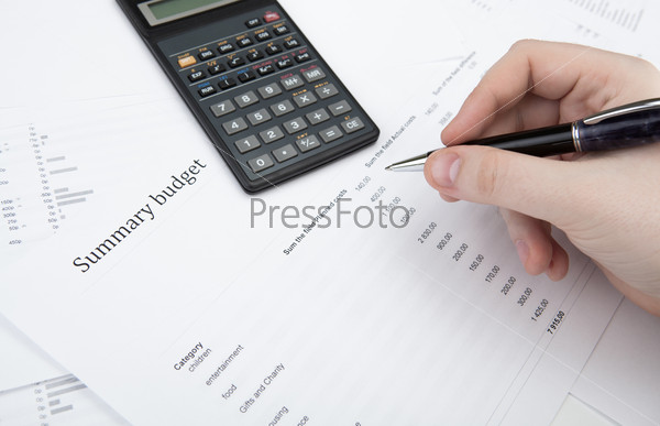 Businessman holding a pen and counts the budget