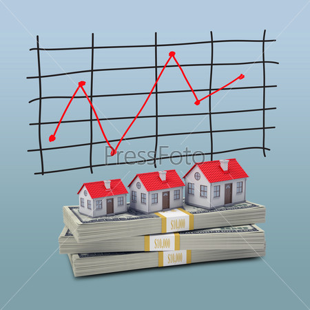 Small houses stand on pack of dollars. Schedule price changes in the background
