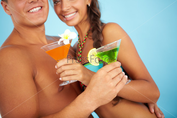 Close-up of cute girl and handsome man with cocktails at beach party