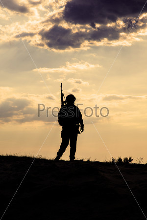 Silhouette of US soldier with rifle  against the sunset