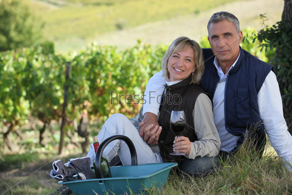couple of radiant wine-growers posing in vineyards
