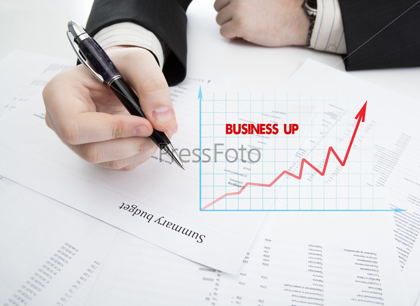 businessman holding a pen and counts the budget on the desktop