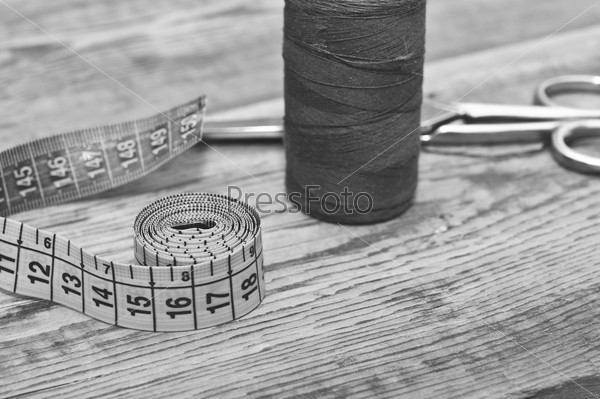 Sewing kit. Scissors with thread and needles on wooden table