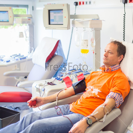 Blood donor at donation with a bouncy ball holding in hand.