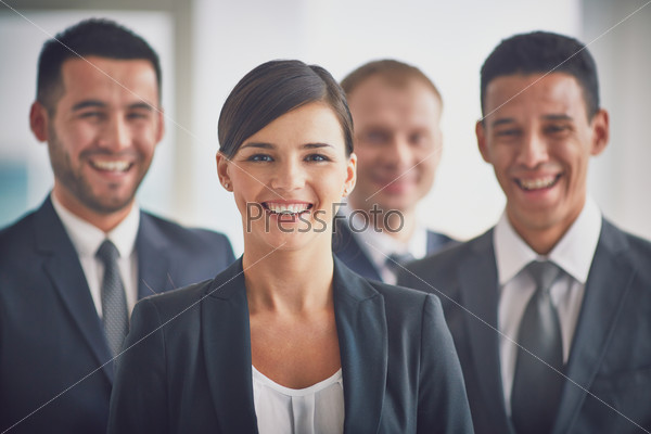Portrait of confident business partners looking at camera, young smiling woman on foreground