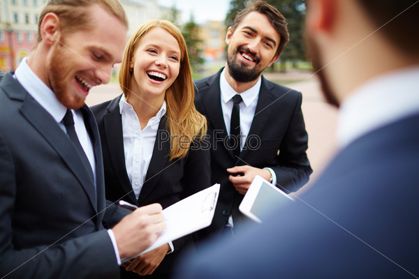 Happy businesswoman looking at colleague while discussing ideas at meeting outside