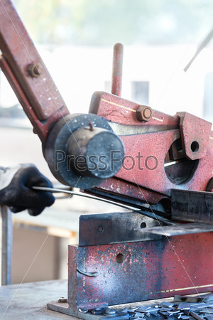 Craftsman cutting Metal with skip in workshop