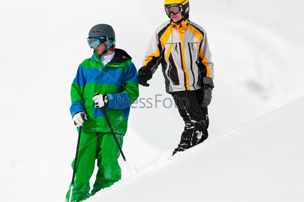 Skier and snowboarder in the snow looking into an alpine winter landscape in anticipation of the next downhill race, stock photo