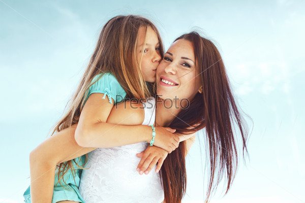 Mother with her 7 years old daughter having fun at beach in summer