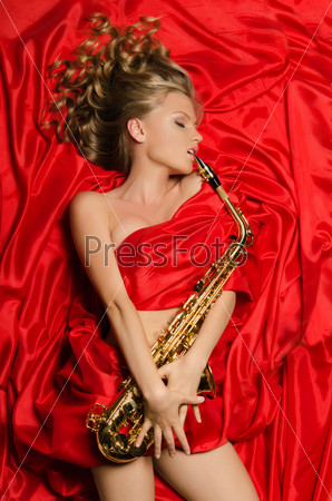 Woman in red dress enjoys playing the saxophone