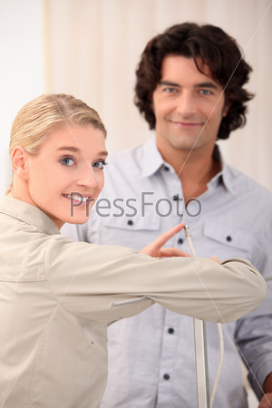 Woman pointing the end of a cable out to a man