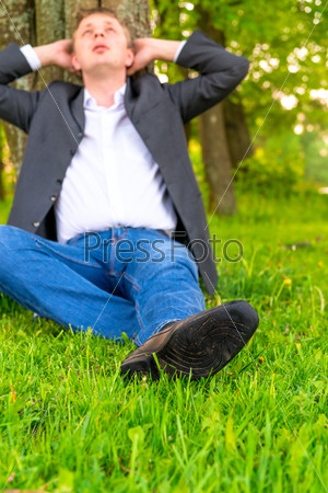 businessman relaxes on a green lawn
