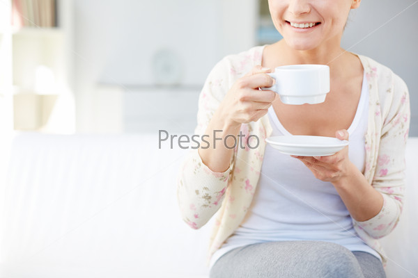 Image of young smiling woman drinking tea
