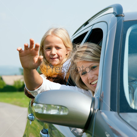 Family travelling by car, mother waving with hands