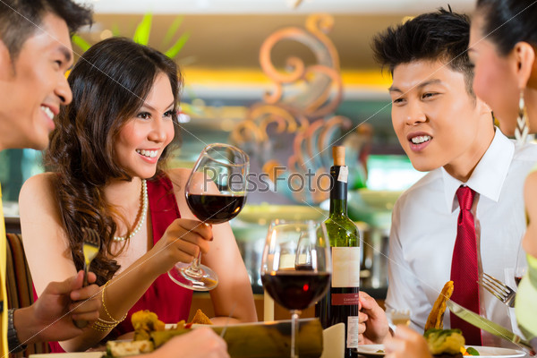 Chinese couples toasting with wine in restaurant