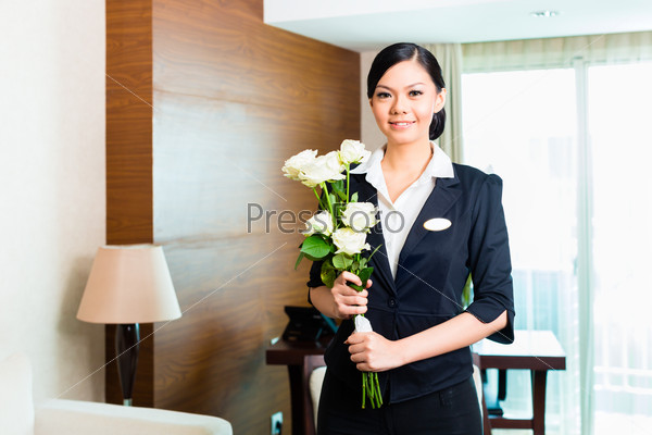 Hotel Manager or director or supervisor welcome arriving VIP guests with roses on arrival in luxury or grand hotel