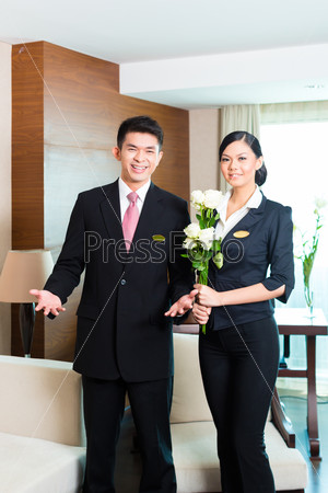 Hotel Manager or director and supervisor welcome arriving VIP guests with roses on arrival in luxury or grand hotel