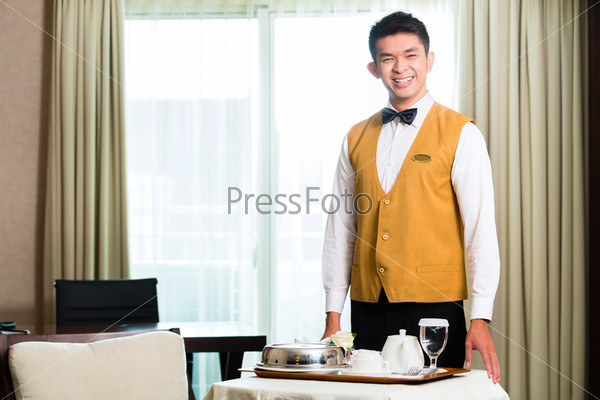 Asian Chinese room service waiter serving food in hotel