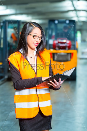 Logistics - female worker or supervisor using tablet computer at warehouse of freight forwarding company