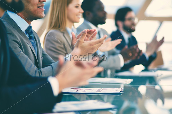 Hands of business partners applauding to reporter after listening to presentation at seminar, blurry