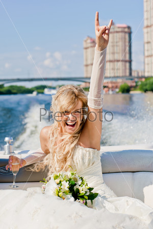 happy bride on a boat sailing with his hand raised up