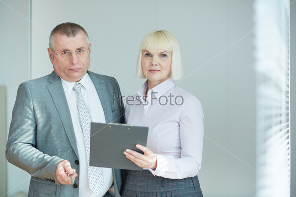 Confident mature co-workers looking at camera