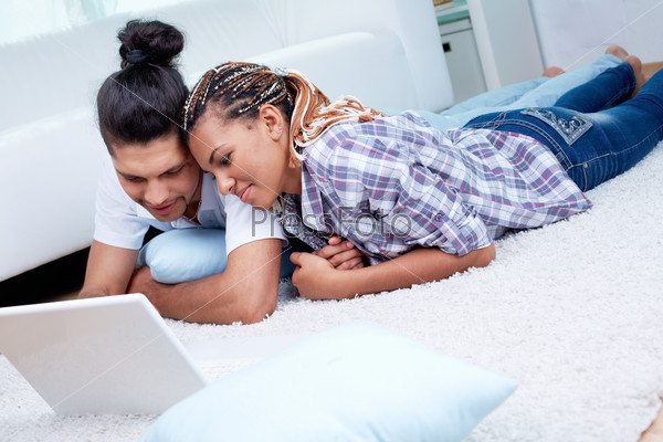 Image of young guy and his girlfriend using laptop at home