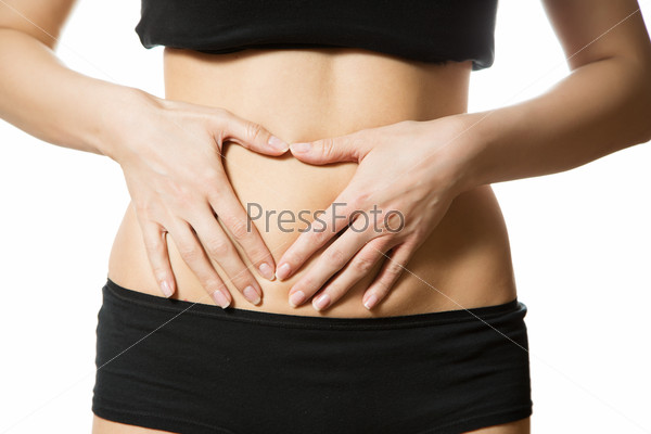 Young woman with hand in heart shape on her tummy. Part of body. Close-up. Isolated over white background.