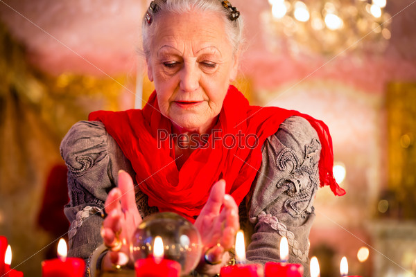 Female Fortuneteller or esoteric Oracle, sees in the future by looking into their crystal ball during a Seance to interpret them and to answer questions
