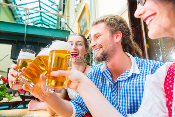 Friends drinking beer in Bavarian restaurant or pub