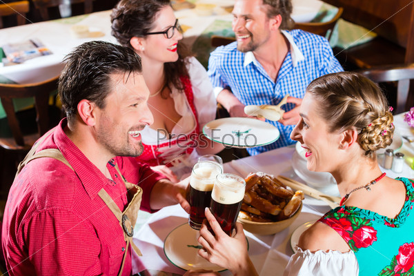Люди пьют пиво в баварском ресторане