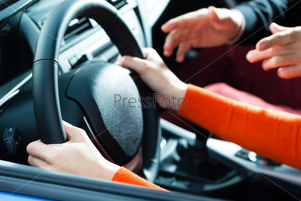 Driving School - Young woman steer a car with the steering wheel, maybe she has a driving test perhaps she exercises the parking