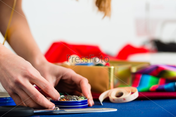 Freelance - tailor or designer working with different utensils, like cotton reels, spools, and colorful fabrics